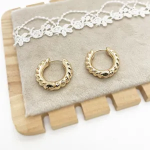 Detailed view of golden twisted alloy hoop earrings with elegant texture