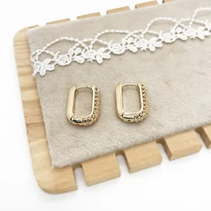 Detailed macro view of gold-tone U-shaped earrings with a unique textured finish