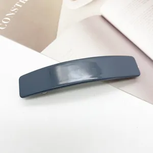Gros plan d'une barrette rectangulaire en acétate gris foncé pour coiffure féminine