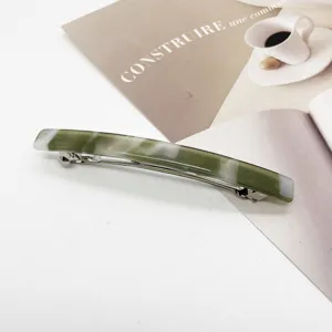 Detailed macro view of an elegant marbled green and white resin barrette hair clip