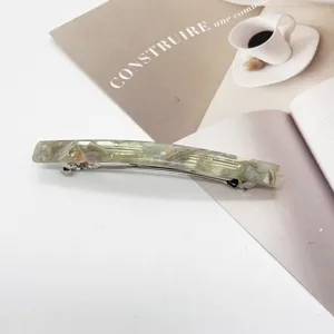Close-up detail of a rectangular resin spring hair clip with green marble texture