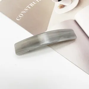 Détail d'une élégante pince à cheveux rectangulaire en acétate marbré gris pour femme