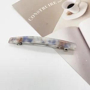 Macro shot of a minimalist rectangular resin hair clip with blue marble pattern