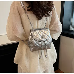 Stylischer silberner gesteppter Mini-Rucksack mit Kettenriemen an einem Modell