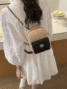 Stylish straw and black leather patchwork backpack with elegant silver twist-lock.