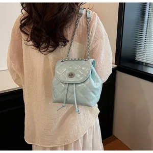 Detailansicht eines hellblauen gesteppten Lackleder-Minirucksacks an einem Modell.