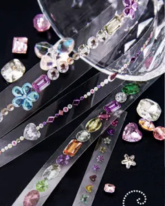 Gros plan d'un ruban adhésif décoratif transparent aux motifs de pierres précieuses colorées.