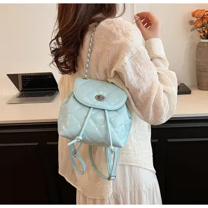 Detailansicht eines hellblauen gesteppten Lederrucksacks mit Kettenriemen am Modell