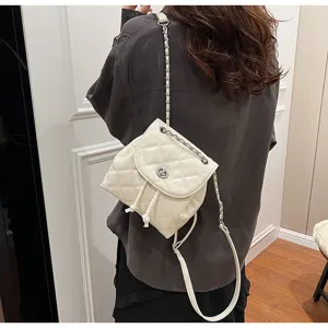 Detailansicht eines weißen Mini-Rucksacks mit Steppmuster, Kettenriemen und Drehverschluss