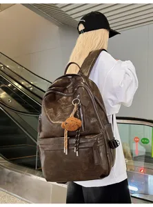 Back view of person wearing large vintage brown soft leather commuter backpack