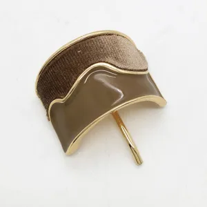 Dettaglio di un elegante gancio per capelli a U con velluto marrone e smalto oliva