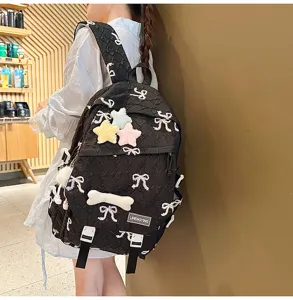 Mochila acolchada negra con bordado de lazos y colgantes de peluche para estudiantes