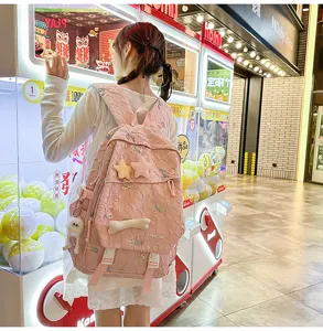 Detalle lifestyle de mochila escolar rosa con bordado de mariposas y colgantes