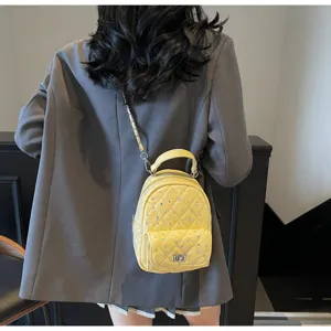 Detailed view of yellow mini quilted backpack with rhinestones and elegant chain strap