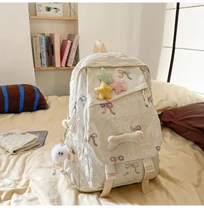 Detalle de mochila acolchada blanca con bordado de lazos lindos y estrellas