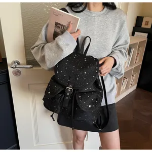 Detail shot of black star pattern women's backpack with drawstring and flap cover