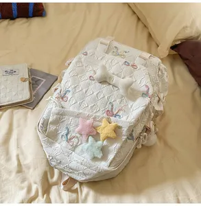 Primer plano de mochila acolchada blanca con lazos bordados y estrellas de peluche