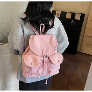 Detailed shot of a pink star-patterned backpack with drawstring flap worn by a model