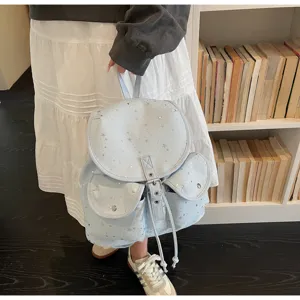 Detail view of stylish light blue drawstring backpack with silver star patterns