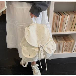 Cream-colored campus style backpack with silver star pattern and drawstring flap