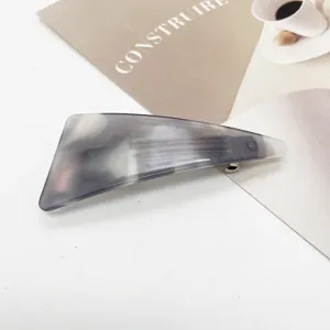 Detail view of grey marble resin hair clip with elegant geometric triangular shape
