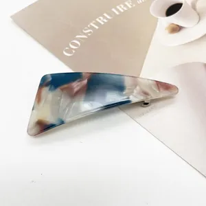 Close-up of marble pattern resin hair clip with elegant geometric triangular design