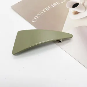 Close-up of a minimalist olive green triangular resin hair clip with spring mechanism