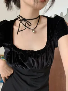 Vue détaillée d'un collier ras du cou noir avec nœud et pendentif cœur en argent