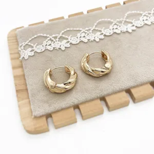 Detailed macro view of gold twisted hoop earrings with elegant minimalist design