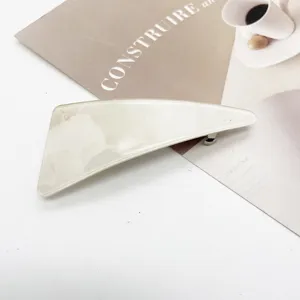 Detailed view of cream marble resin geometric hair clip with secure spring fastening