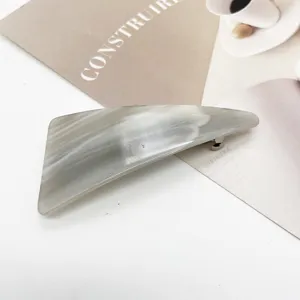 Macro view of the elegant grey marble resin hair clip with geometric triangular shape