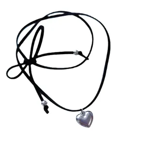 Vue détaillée du collier cordon en cuir avec pendentif cœur en acier et nœud papillon