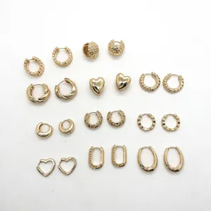Collection of various gold-toned geometric hoop and heart-shaped stud earrings on white.
