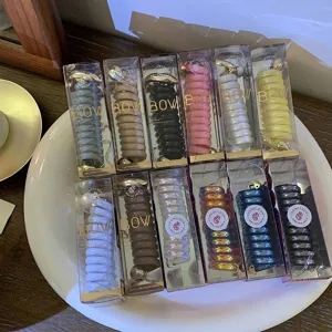 Assorted colorful telephone wire hair rings displayed in transparent gift box packaging
