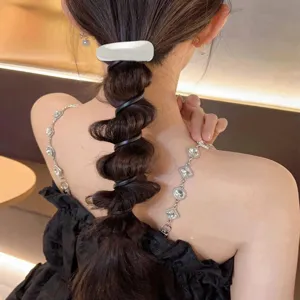Rear view of a bubble braid hairstyle using a black spiral telephone line hair tie accessory