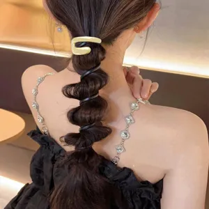 Back view of a woman wearing a gold metallic spiral hair tie for a bubble braid