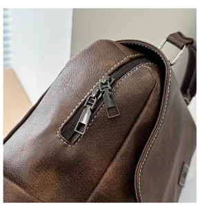 Dettaglio delle doppie cerniere e della pelle PU marrone su uno zaino vintage