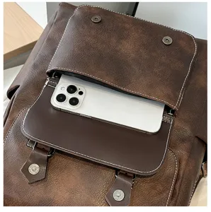 Dettaglio della tasca frontale di uno zaino vintage in pelle PU marrone con telefono.