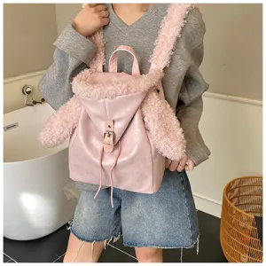 Detalle de una mochila rosa con orejas de conejo y correas de felpa suave sobre la modelo
