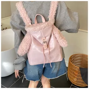 Vista trasera de una mochila rosa con correas de orejas de conejo de peluche