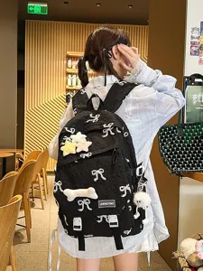 Mochila acolchada negra linda con bordado de lazos decorativos y suaves dijes de peluche