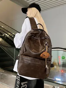 Large capacity retro soft brown leather backpack with teddy bear charm for urban commuting style