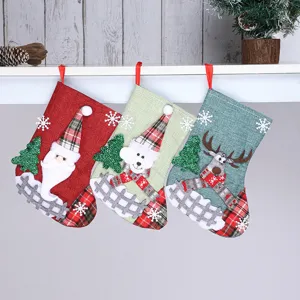 Detailed view of three festive Christmas stockings hanging with Santa, bear and reindeer designs.