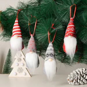 Close up view of cute hanging Christmas gnomes, knit holiday tree ornaments with white beards.