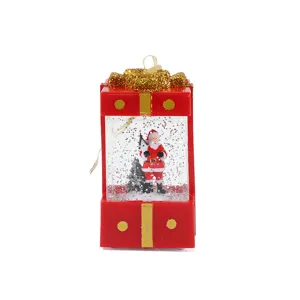 Lanterna ad acqua con scatola regalo rossa di Babbo Natale e glitter per decorazioni.