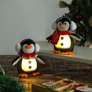 Peluche pinguino di Natale luminoso con pancia a LED in scena festiva