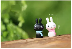Gros plan détaillé de figurines de mini lapins noirs et blancs avec des écharpes colorées pour bricolage.
