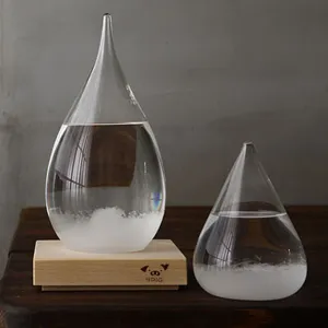 Detail view of creative teardrop glass storm weather forecast bottles on a wooden base.