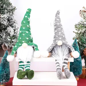 Dettaglio peluche gnomo di Natale, bambola seduta con berretto in maglia e gambe penzolanti.