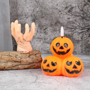 Halloween LED pumpkin light and zombie hand decoration prop for spooky party and home decor.